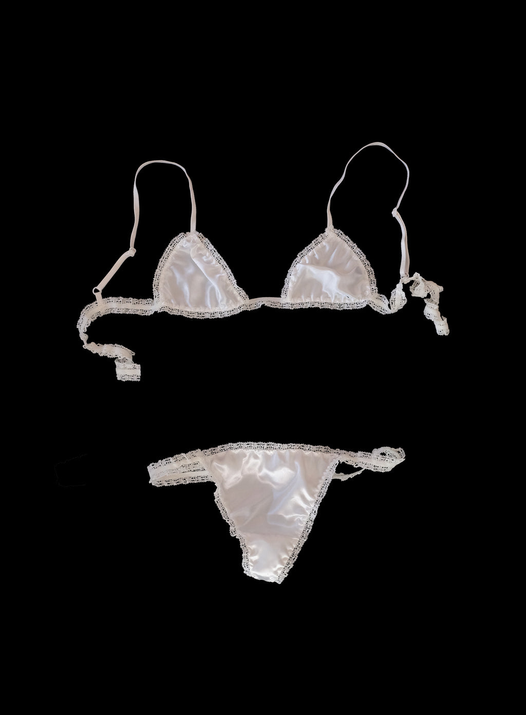 Luxury off-white silky satin lingerie set featuring triangle bra with wide center gore and low-rise t-bar thong, delicate lace elastic trim, tie-back closure, 100% satin handcrafted in London